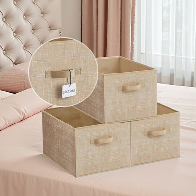 3 sand beige fabric storage bins on a bed with a close-up of the label tag