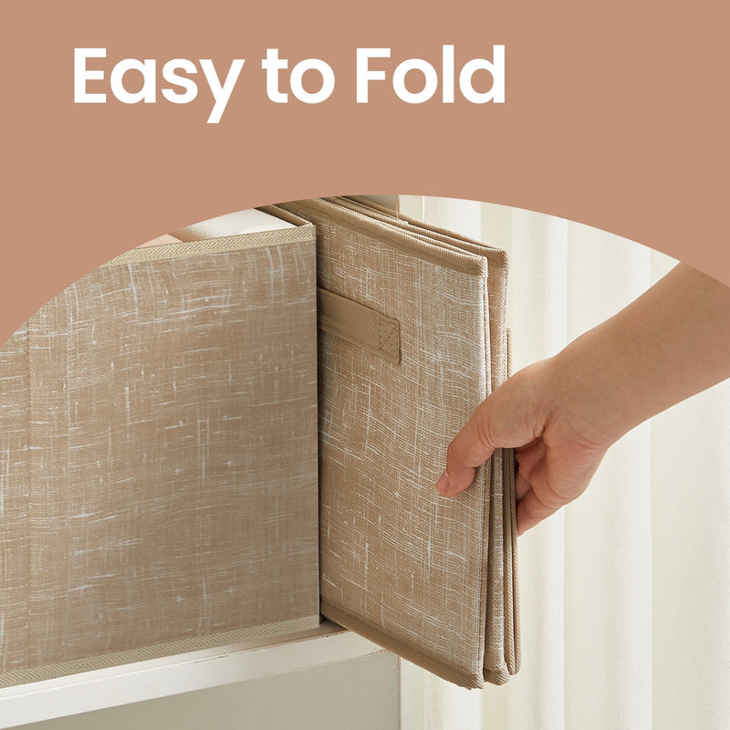 A hand holding one storage bin folded flat for storage