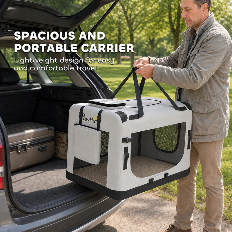 Man lifting the pet carrier by its top handles beside an open car boot