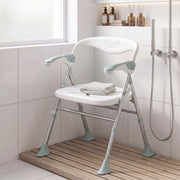 Foldable shower chair set up in a shower cubicle with a folded towel on the seat