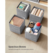 Four open storage cubes filled with books, towels, a folded blanket and toys