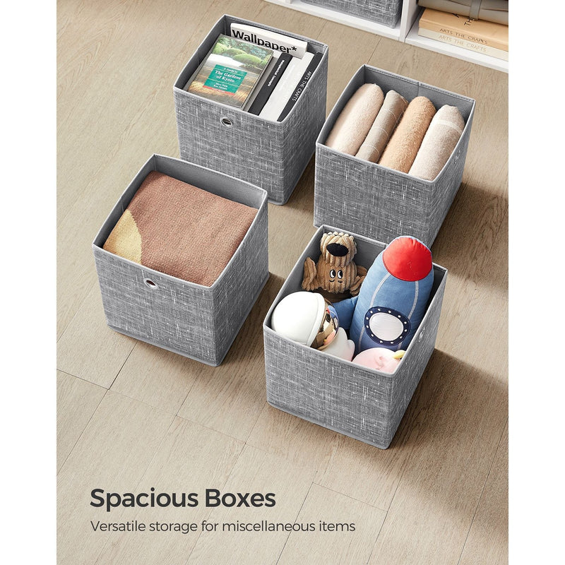 Four open storage cubes filled with books, towels, a folded blanket and toys
