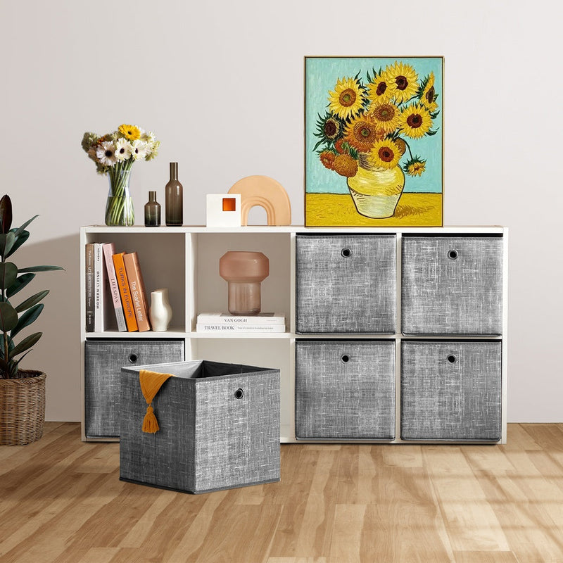 Heathered grey storage cubes filling a white cube shelving unit in a living room