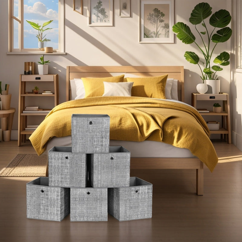 Six heathered grey storage cubes stacked in a pyramid beside a wooden bed