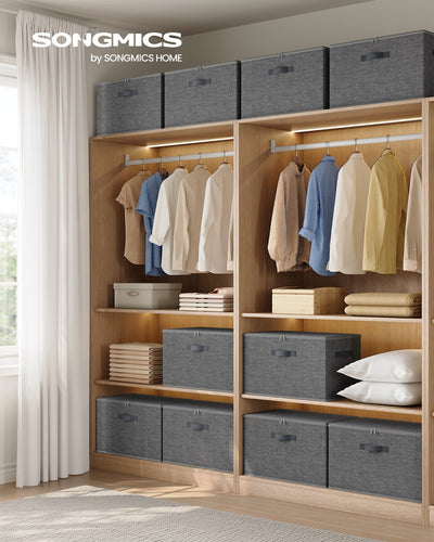 Slate grey storage boxes styled on wardrobe shelves alongside hanging clothes and folded linens