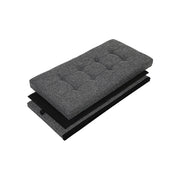 The ottoman folded flat, showing the quilted padded lid and collapsed fabric panels