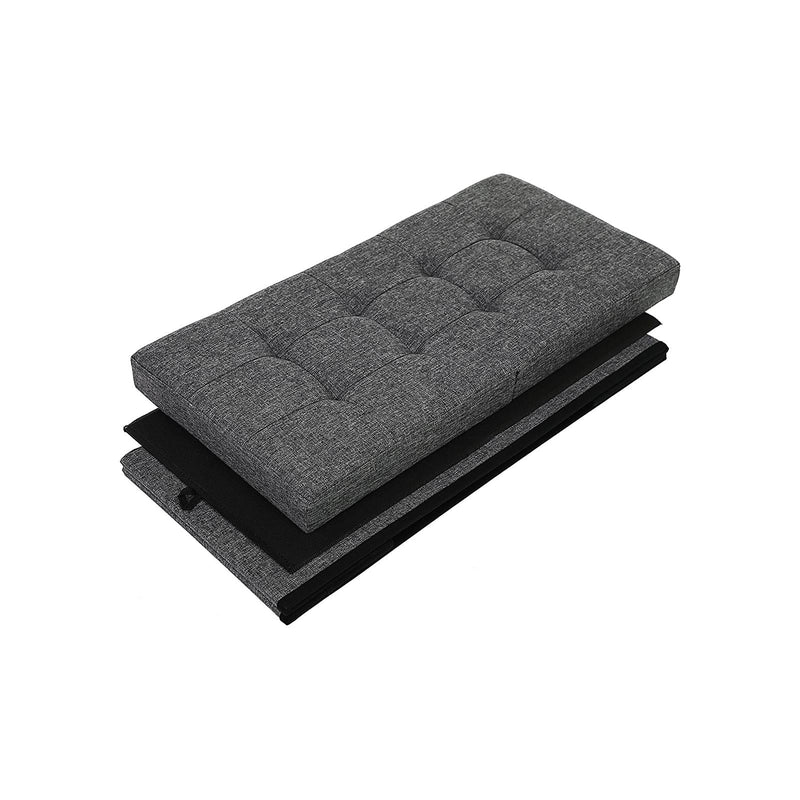The ottoman folded flat, showing the quilted padded lid and collapsed fabric panels