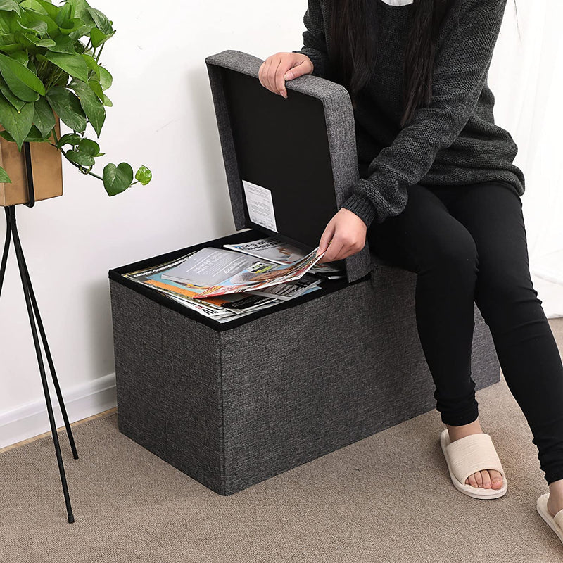 Woman sitting on one half of the lid while lifting magazines from the open half