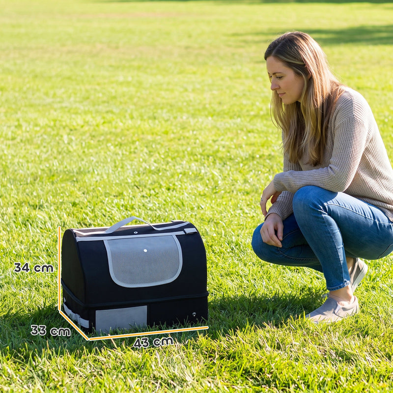 Black travel cat litter box on grass beside a woman with 43 x 33 x 34 cm dimensions marked
