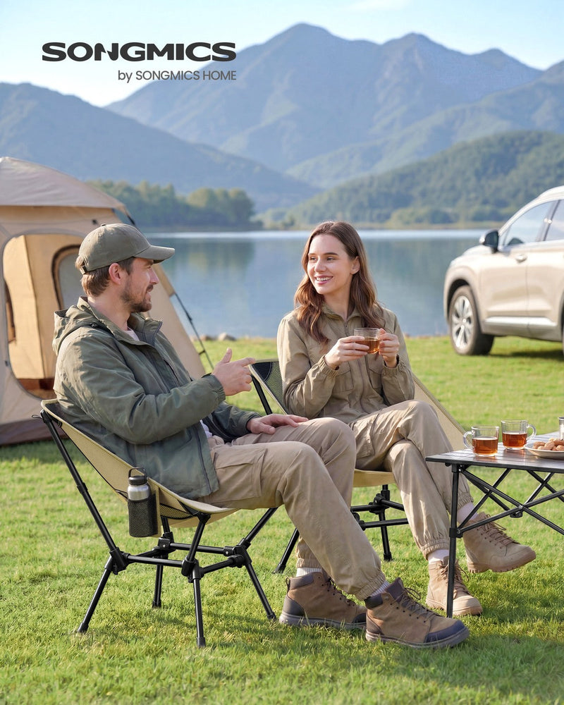 Two people sitting in khaki Songmics camping chairs by a tent and lake