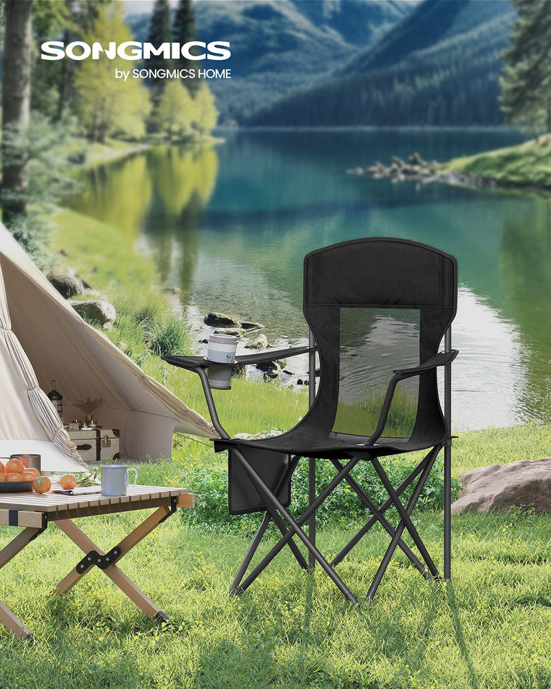 Ink black Songmics camping chair set up on grass beside a lakeside tent