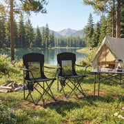 Ink black camping chairs pitched outside a tent beside a mountain lake