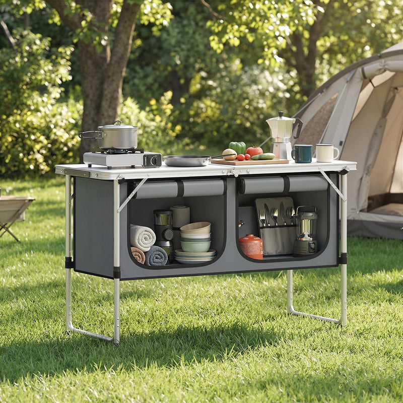 Camping cupboard set up at a campsite with cookware near a tent