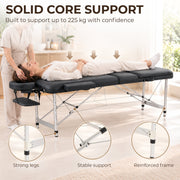 Therapist massaging a client on the table beside a 225 kg support banner