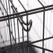 Close-up of a metal door latch hooked over the crate bars