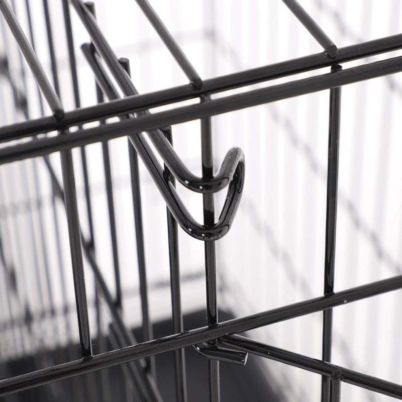 Close-up of a metal door latch hooked over the crate bars