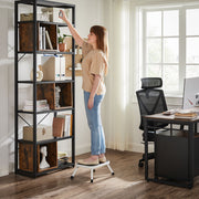 Woman using the step stool to reach a high shelf on a home office bookcase