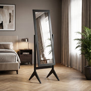 Freestanding mirror styled in a bedroom beside a nightstand and curtains