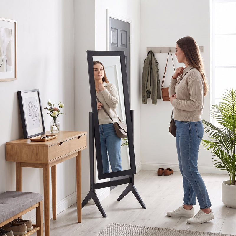 Freestanding mirror styled in a hallway entryway with coat hooks