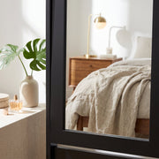 Close-up of the mirror frame corner beside a bedside table
