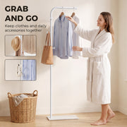 Woman taking a shirt from the white clothes rail, with close-ups of the hooks holding a hat and bag