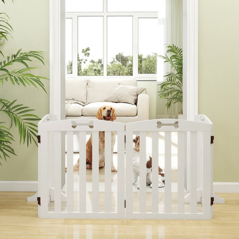 Two dogs sitting behind the dog gate in a living room doorway