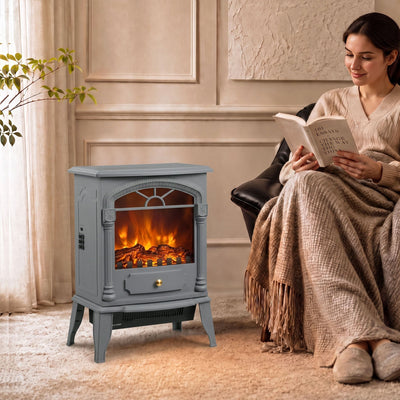 Electric stove fireplace beside an armchair while a woman reads under a blanket