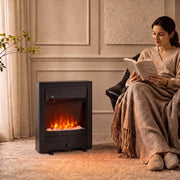 Electric fireplace with glowing flames beside an armchair as a woman reads under a blanket