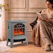 Grey electric fireplace stove glowing beside an armchair while a woman reads in a cosy living room