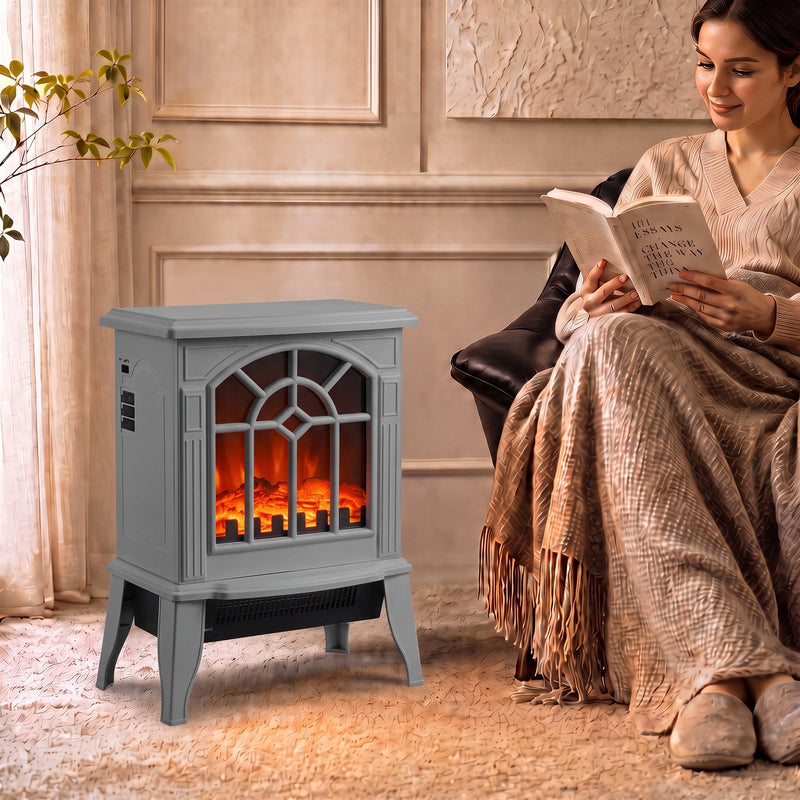 Grey electric fireplace stove glowing beside an armchair while a woman reads in a cosy living room