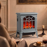 Grey electric fireplace stove lit in a living room beside a candle and coffee table, viewed from an angle