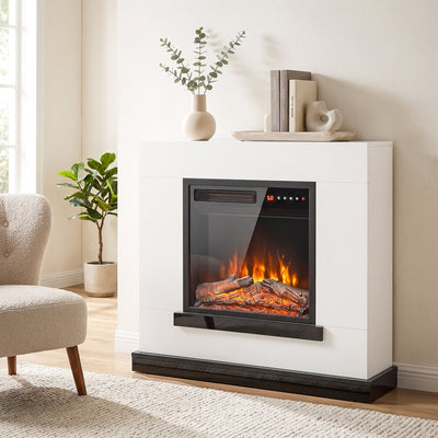 White electric fireplace suite in a living room beside a vase, books and an armchair