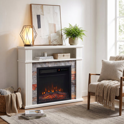 White electric fireplace suite in a living room beside an armchair and decor