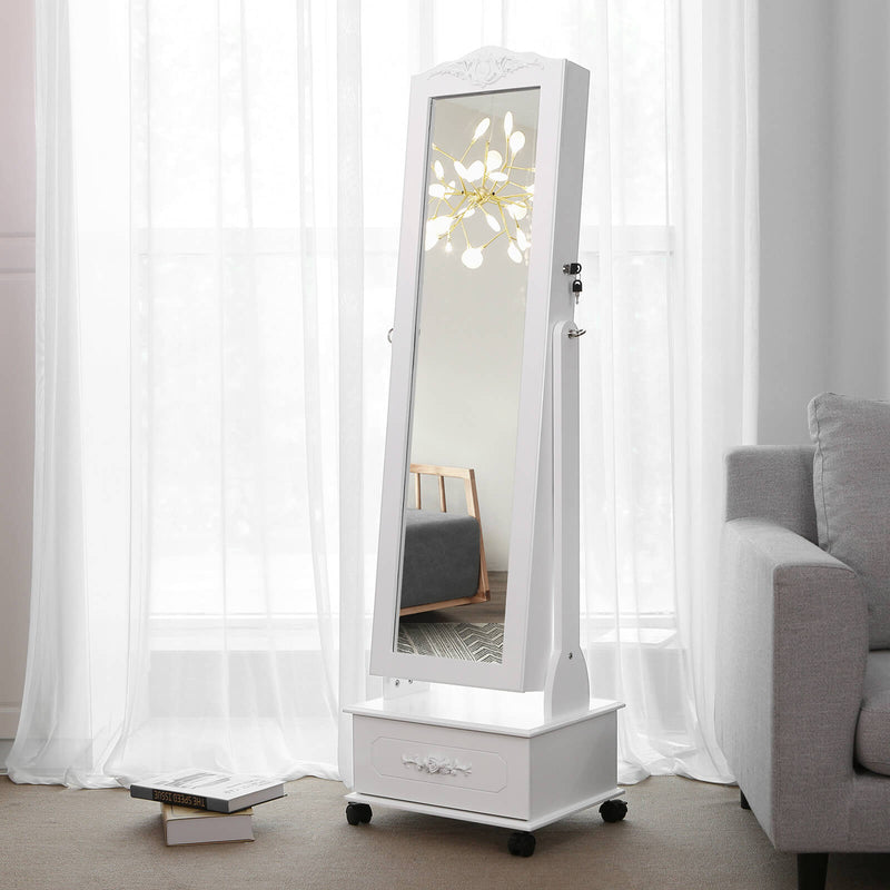 White jewellery armoire standing closed beside a sofa with daylight on the mirror