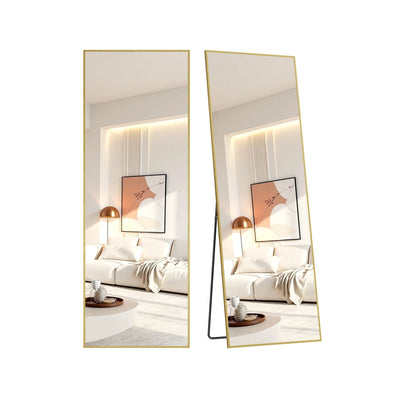 Pale-gold aluminium-framed full-length mirror shown from front and angled views leaning against a wall, reflecting a minimalist living room.