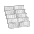 Ten galvanised steel gabion cages stacked and ready for garden wall building