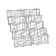 Ten galvanised steel gabion cages stacked and ready for garden wall building
