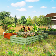 Light green raised garden bed planted with foliage and flowers next to an orange pot