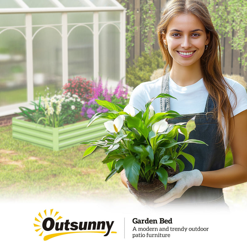 Gardener holding a potted plant beside the light green Outsunny garden bed