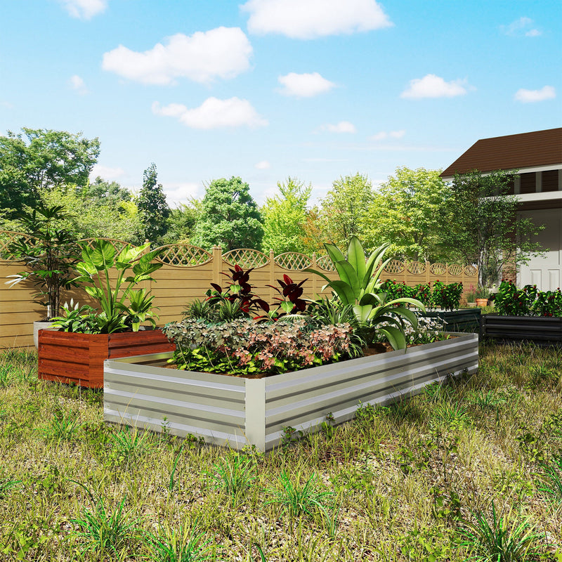 Silver raised garden bed planted with foliage and flowers next to an orange pot