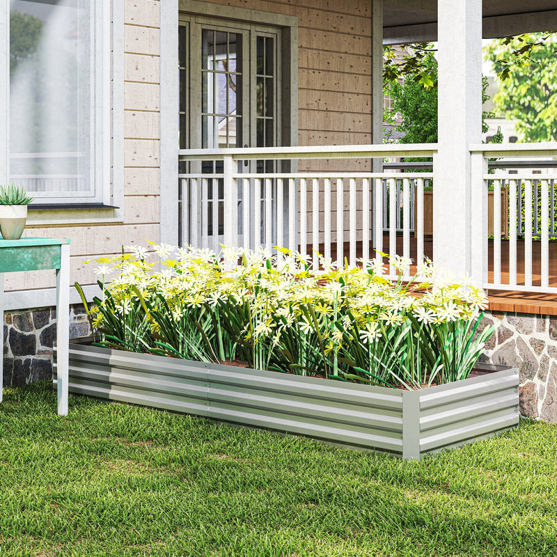 Silver raised garden bed with white flowers on the grass in front of a porch