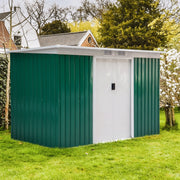 Green shed sited on a lawn with mature trees behind