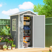Outsunny 4x3ft plastic shed on a patio deck with the door open, shelves holding boxes and tools