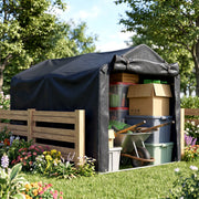 Black storage tent beside a wooden fence holding boxes, crates and a wheelbarrow