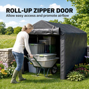 Woman wheeling a wheelbarrow of crates into the dark grey tent through the roll-up zipper door