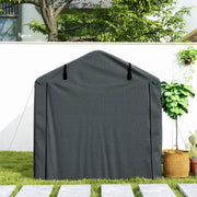Front view of the dark grey storage tent with the door zipped shut beside a potted plant