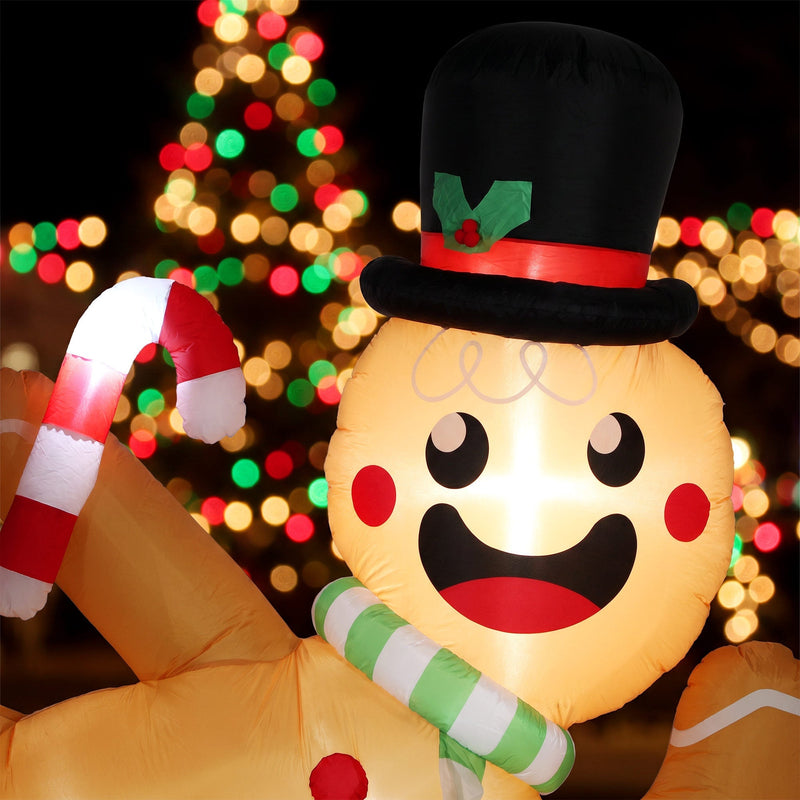 Close-up of the smiling gingerbread man face, black top hat and candy cane