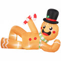 Light brown inflatable gingerbread man lying on its side holding a candy cane, white studio shot