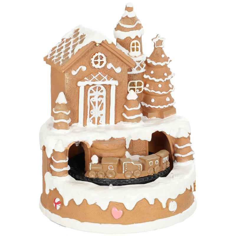 Studio shot of the brown gingerbread house Christmas village with rotating train