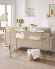 Gold console table behind a cream sofa in a bright living room